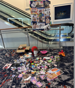 A cardboard image of polka dancers on an escalator surrounded by ribbons and various gifts.